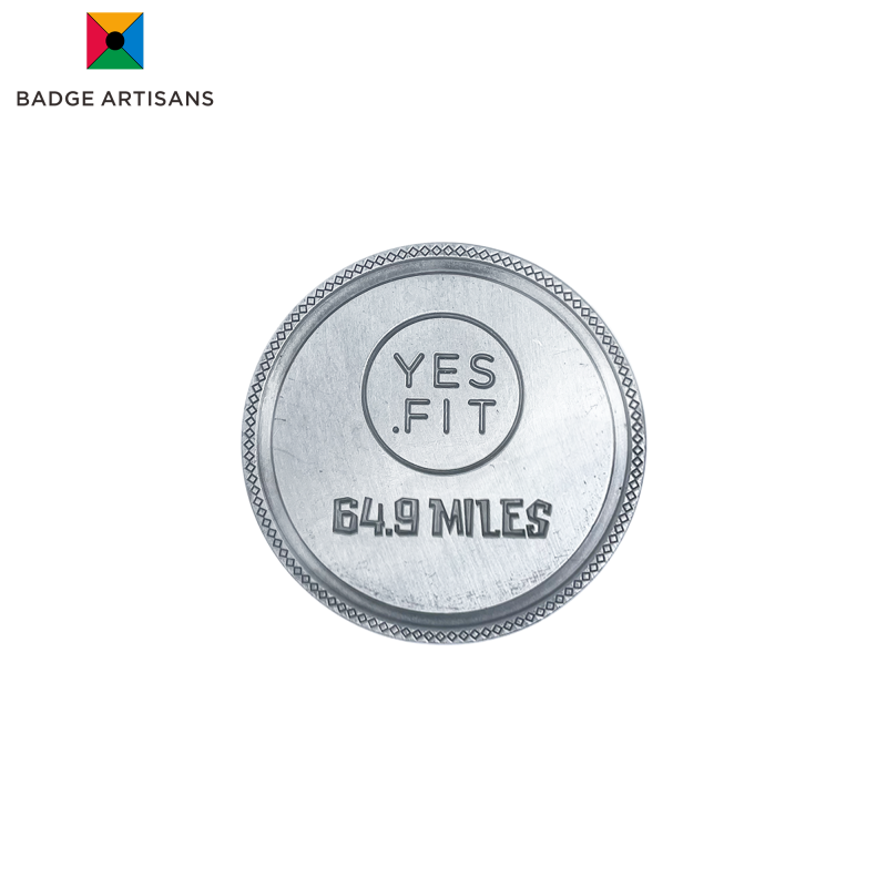 alt="YES .FIT ‘Lord of the Jungle’ coin reverse with engraved YES .FIT logo, bold ‘64.9 MILES’ text and diamond‑patterned border on brushed zinc alloy